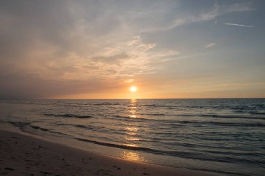 Görüntü kumlu bir plaj gün batımında