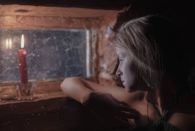 pencerenin loş ışık ile ahşap bir evde kız