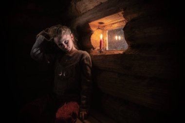 pencerenin loş ışık ile ahşap bir evde kız