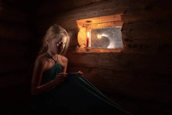girl by the window in a wooden house with dim light