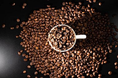 bir desen ve taneleri kahve siyah bir zemin üzerine beyaz bardak