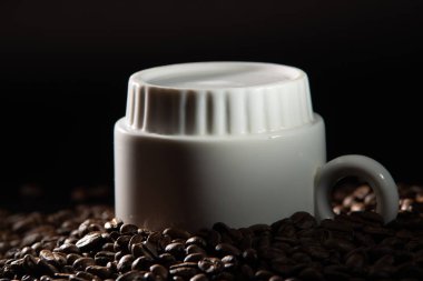 bir desen ve taneleri kahve siyah bir zemin üzerine beyaz bardak