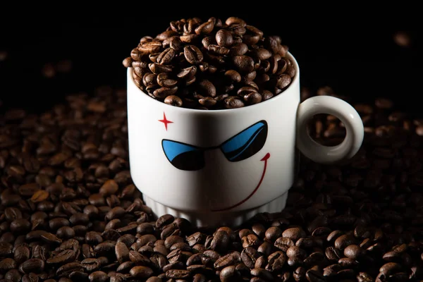 white cups with a pattern and grains of coffee on a black background