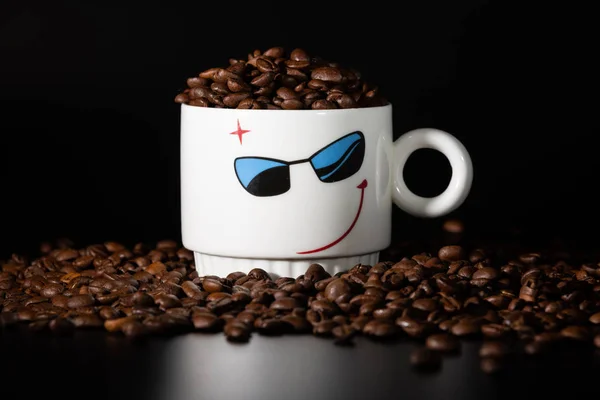 white cups with a pattern and grains of coffee on a black background