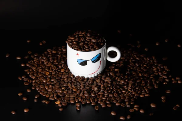 white cups with a pattern and grains of coffee on a black background