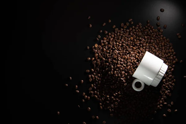 白色杯子与样式和咖啡颗粒在一个黑色的背景 — 图库照片