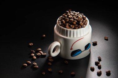 bir desen ve taneleri kahve siyah bir zemin üzerine beyaz bardak