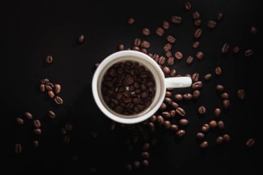 bir desen ve taneleri kahve siyah bir zemin üzerine beyaz bardak