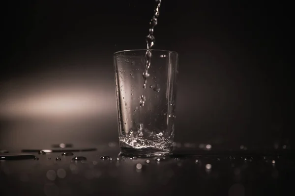 Gegoten Een Zwarte Achtergrond Een Glas Water — Stockfoto