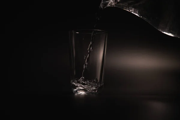 Eau Est Versée Dans Verre Transparent Sur Fond Sombre — Photo