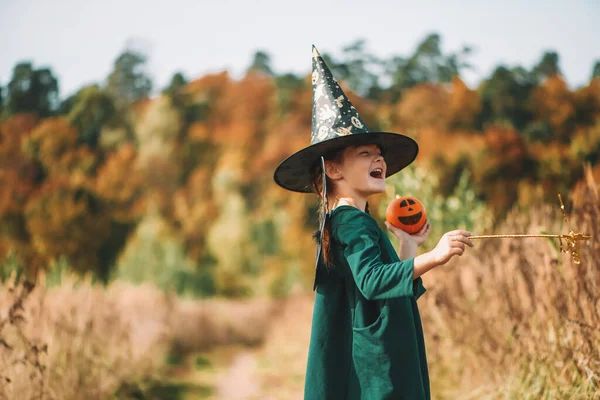 Les enfants Halloween. Jolie fille dans un chapeau tenant une citrouille. — Photo