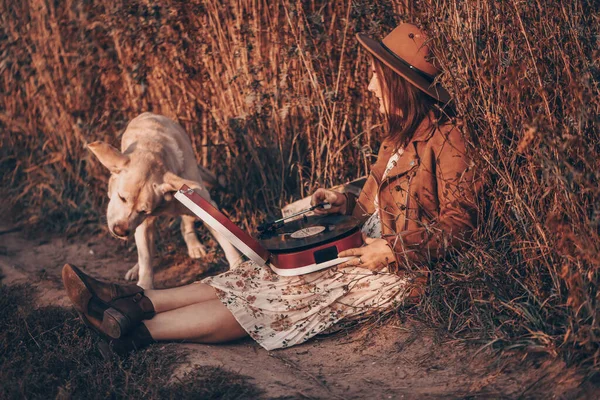 Belle femme assise avec son chien dans le champ. Journée ensoleillée d'automne. — Photo