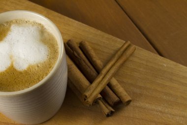 Ahşap zemin üzerine tarçın ile kahve kupa