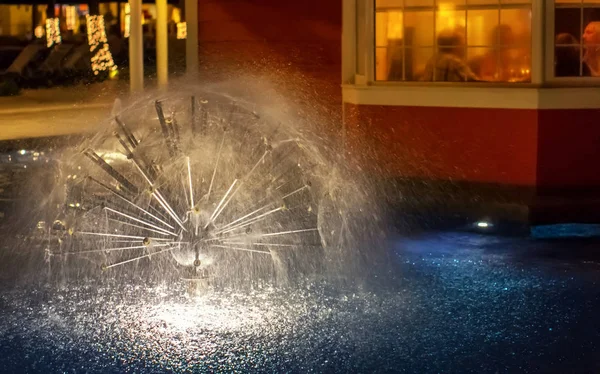 fountain next to the restaurant Windows and people sitting there