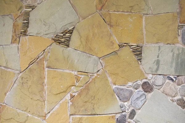 Heterogeneous stone texture. A masonry wall of multicolored stones or blocks.