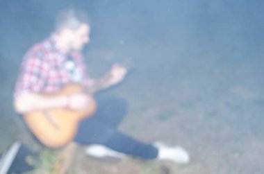 Geceleri doğada gitarist. Bulanık