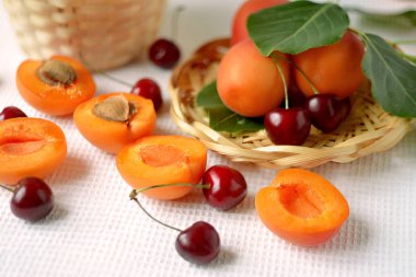 Kayısı ve saman tabakta kiraz yaprakları bir tablo olgunlaşmış meyve ile