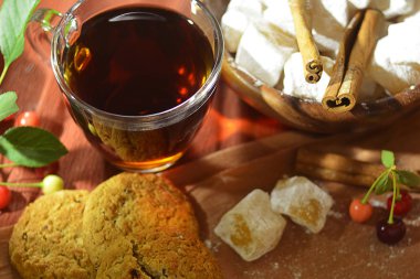 Çay, oryantal tatlılar, kiraz ve tarçın sıcak sesi ile natürmort