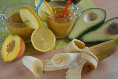 Meyve kokteyli, iki kupalar içinde kokteyller, avokado ve muz ile meyve ile çevrili, şeftali