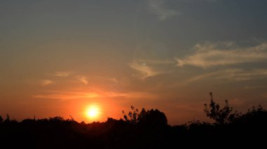 Kara bulutlar üzerinden günbatımı ışınları ile horizo ağaçta bir kontur