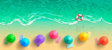 Deniz ve plaj şemsiye, şezlong ve bir can simidi ile üstten görünüm. Kum sörf hattı boyunca çıplak ayak izleri.