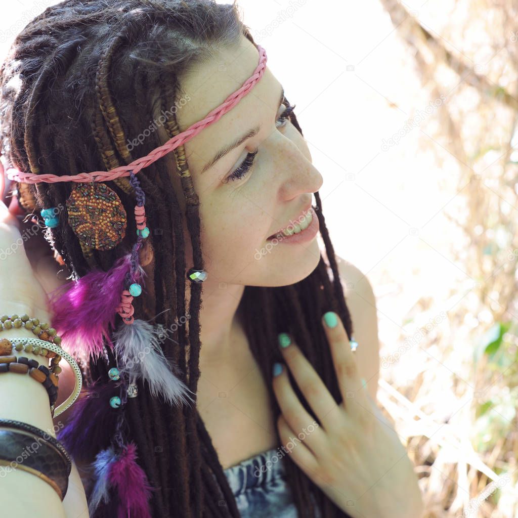 Hippie style young woman with dreadlocks portrait, outdoor in autumn park