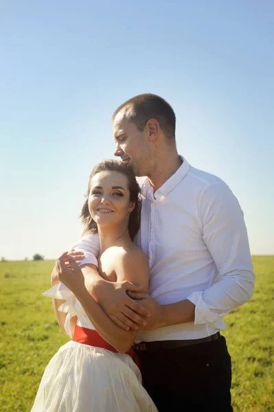 De bruid en bruidegom staan tegen elkaar op een veld — Stockfoto