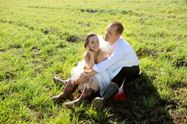 La boda en el pueblo, el novio y la novia se divierten en un campo de hierba —  Fotos de Stock