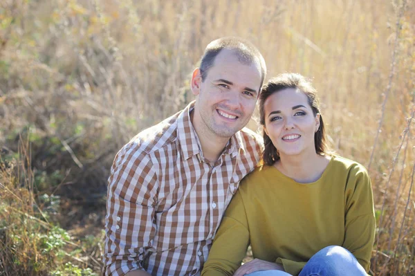 Jovem casal feliz família descansar ao ar livre, olhando para a câmera — Fotografia de Stock