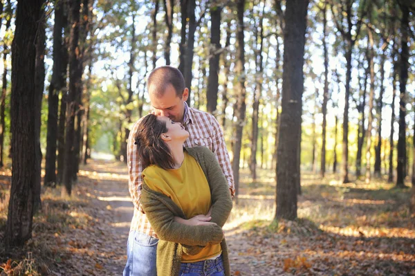 Jovem casal de amor adulto andando na floresta, jovem família ao ar livre, marido beijar sua esposa nos cabelos — Fotografia de Stock