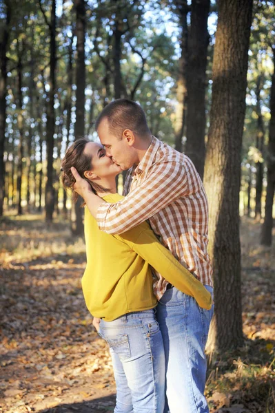 Couple d'amour heureux marchant dans la forêt et s'embrassant, jeune couple romantique adulte, vêtements décontractés — Photo