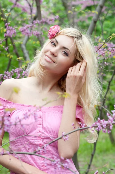 Ritratto sorridente di giovane donna nel parco primaverile vicino all'albero dei fiori — Foto Stock