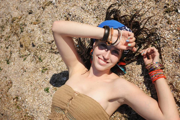 Portrait de femme allongé sur le sable, fille avec dreadlocks — Photo