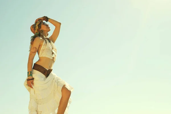 Jovem bela mulher estilo boho de pé ao ar livre contra o céu, cores branqueadas vintage — Fotografia de Stock
