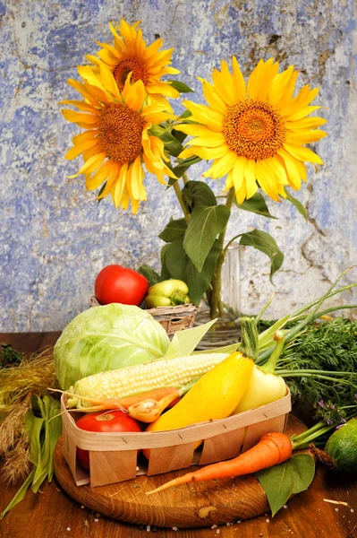 Zonnebloemen boeket en diverse verse groenten in een mandje — Stockfoto