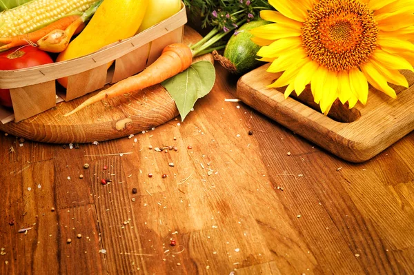 Zonnebloem en rauwe groenten op een houten plank — Stockfoto