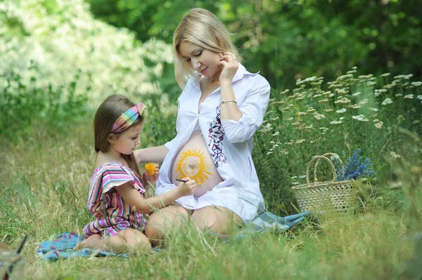 Bambina disegnare un sole sul suo stomaco madre incinta — Foto Stock