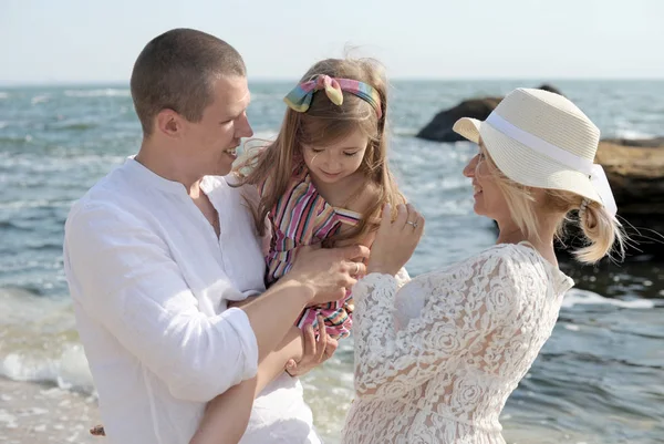 Счастливая семья с дочкой у моря — стоковое фото