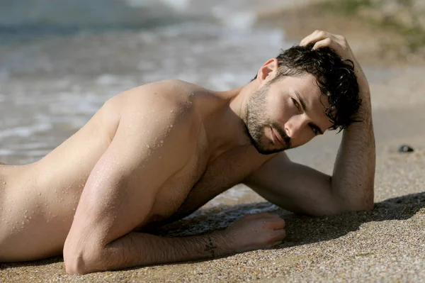 Young sexy man portrait laying in sea water, topless — Stock Photo, Image