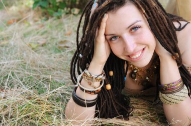 Boho stil gülümseyen kadın portre, kız var eğlenceli bir sonbahar güneşli parkı açık yalan