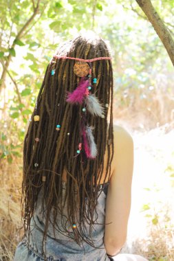Güzel genç kadın bir at kuyruğu toplanan dreadlocks saç modeli ile dekore edilmiş çeşitli boncuklar