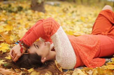 Mutlu dinlenme kız portre, park, akçaağaç yaprakları sonbaharda yalan gözler, moda Kazak giymiş kapalı