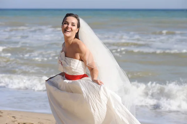 Alegre novia feliz en una costa — Foto de Stock