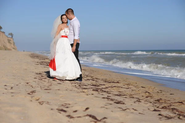 Jonge volwassen bruidspaar zoenen in de buurt van de zee — Stockfoto