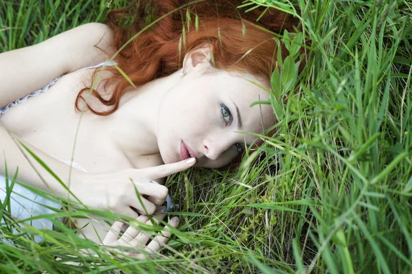 Outdoor portrait of a red hair woman showing shhh, fashion white dress — Stock Photo, Image