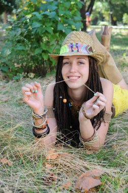 Neşeli kadın, dışarıda eğlen çimenlerde rahatla, ağzında pipetle