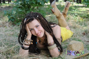 Neşeli kadın, dışarıda eğlen çimenlerin üzerinde rahatla, kameraya bak.