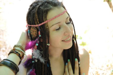 Bağımsız, hippi tarzı, rastalı bir kadın, açık havada.