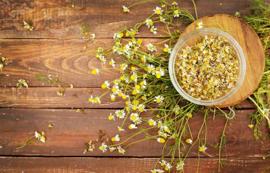 Tahta bir masada, düz manzaralı organik papatya çiçekleri.