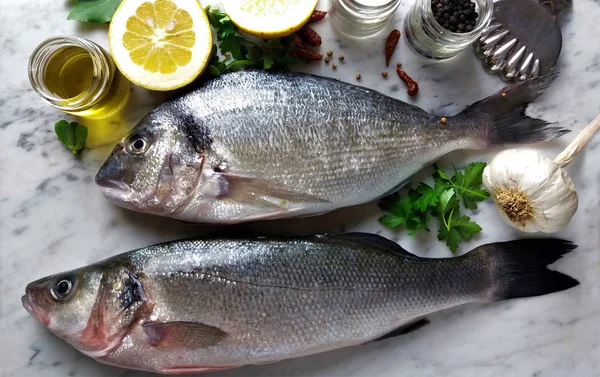 Pescado fresco con limón y especias sobre mármol —  Fotos de Stock